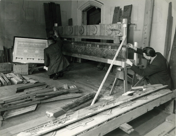 Photograph of craftsmen reassembling the screen using a nineteenth century architectural drawing as a reference, c.1950 (MT/19/PHO/4/3/14)